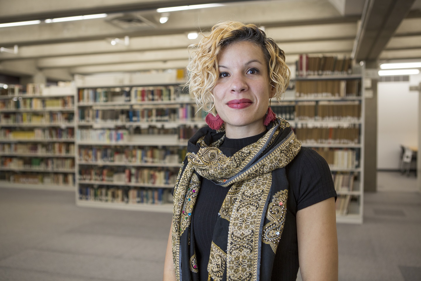 Désirée Rochat standing in front of Vanier Library bookshelves