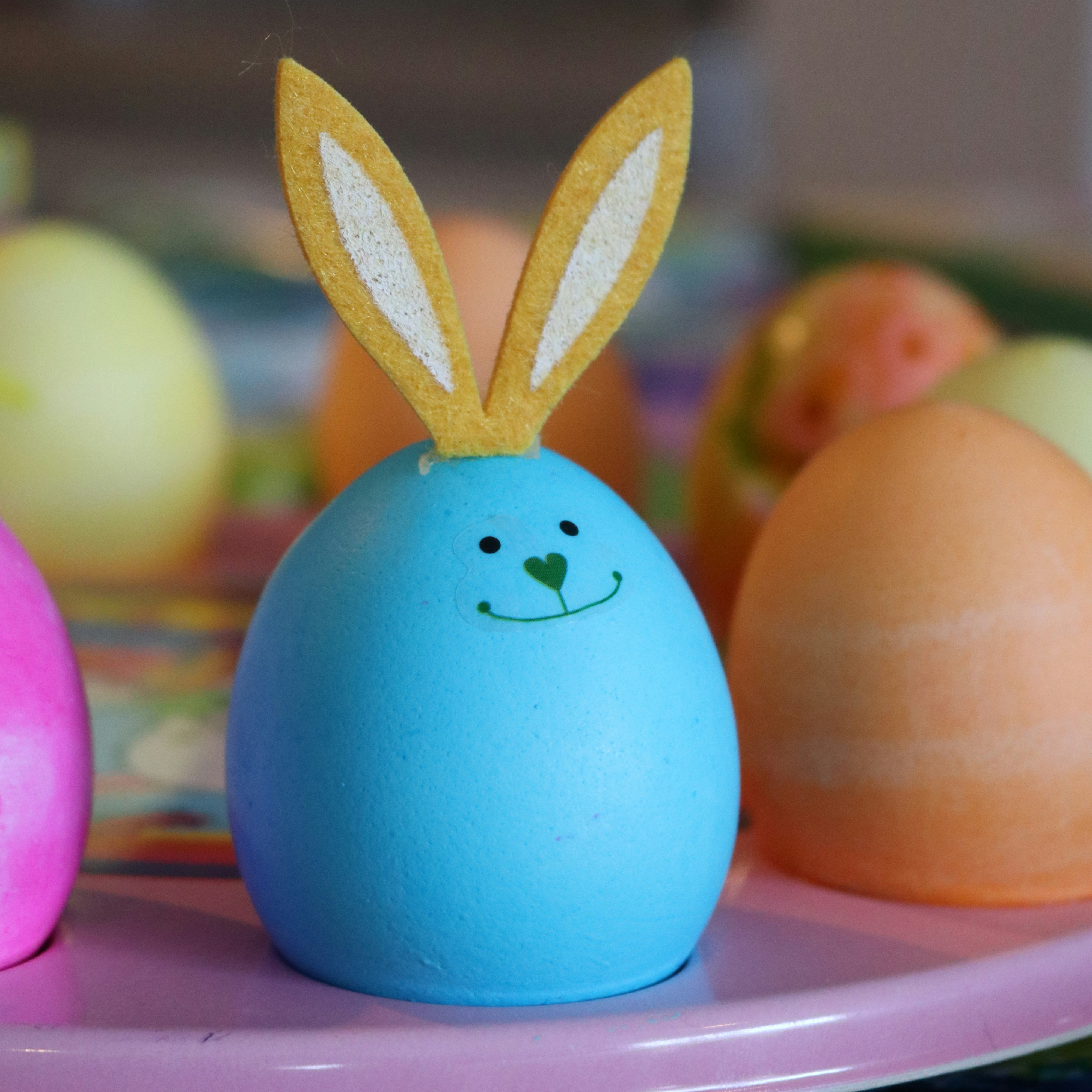 egg dyed blue with a face and cardboard rabbit ears