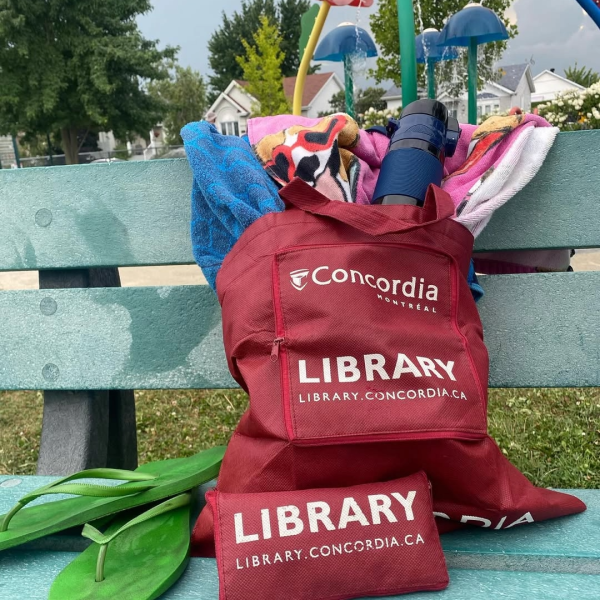 Concordia Library bags on a bench with towels, sandals and water bottle